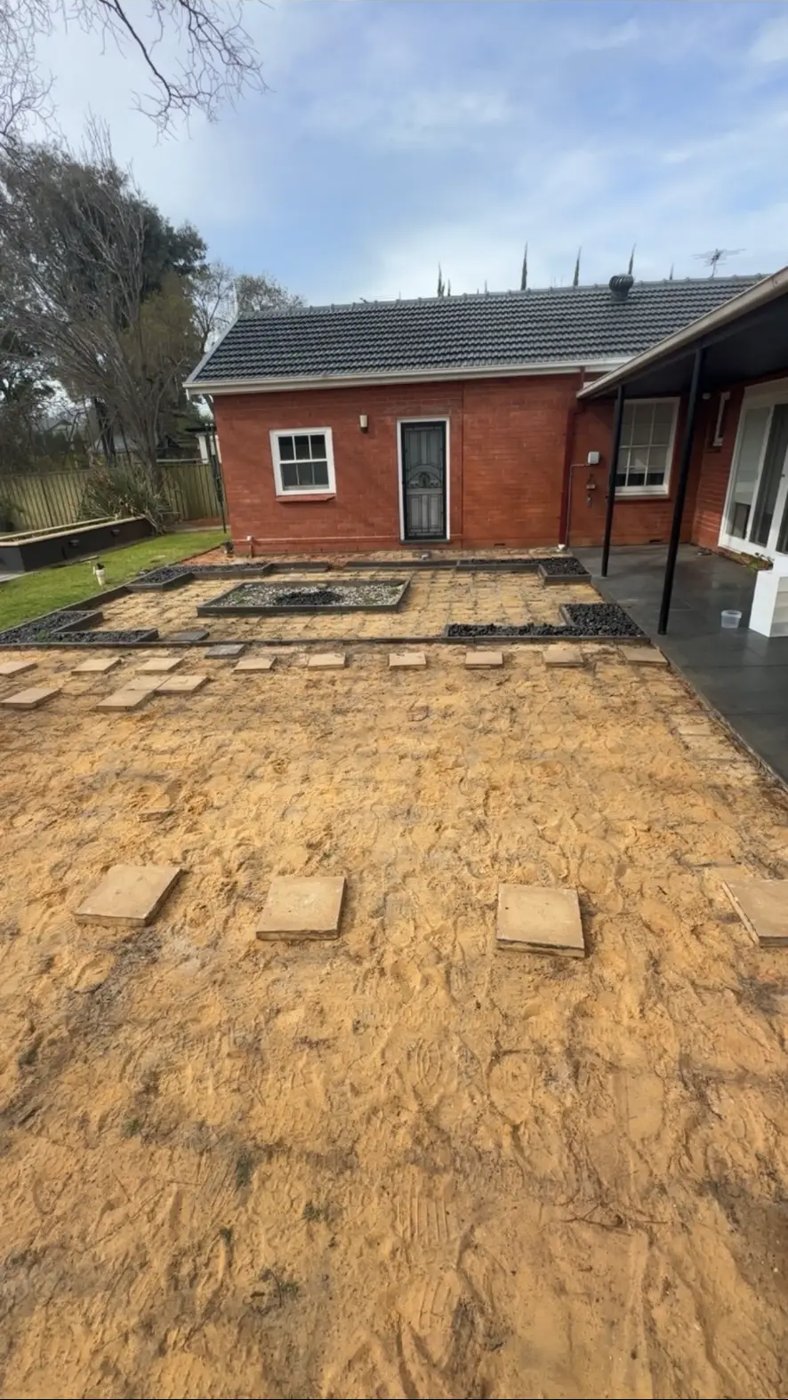 Large rear yard cleared of pavers down to the sand base